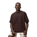 Man wearing a brown Macbee oversized t-shirt and beige shorts on a white background