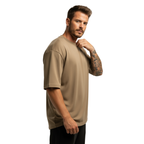 Man wearing a beige Macbee oversized t-shirt on a white background
