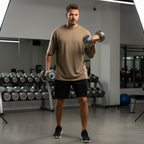 Man exercising with dumbbells in a gym setting
