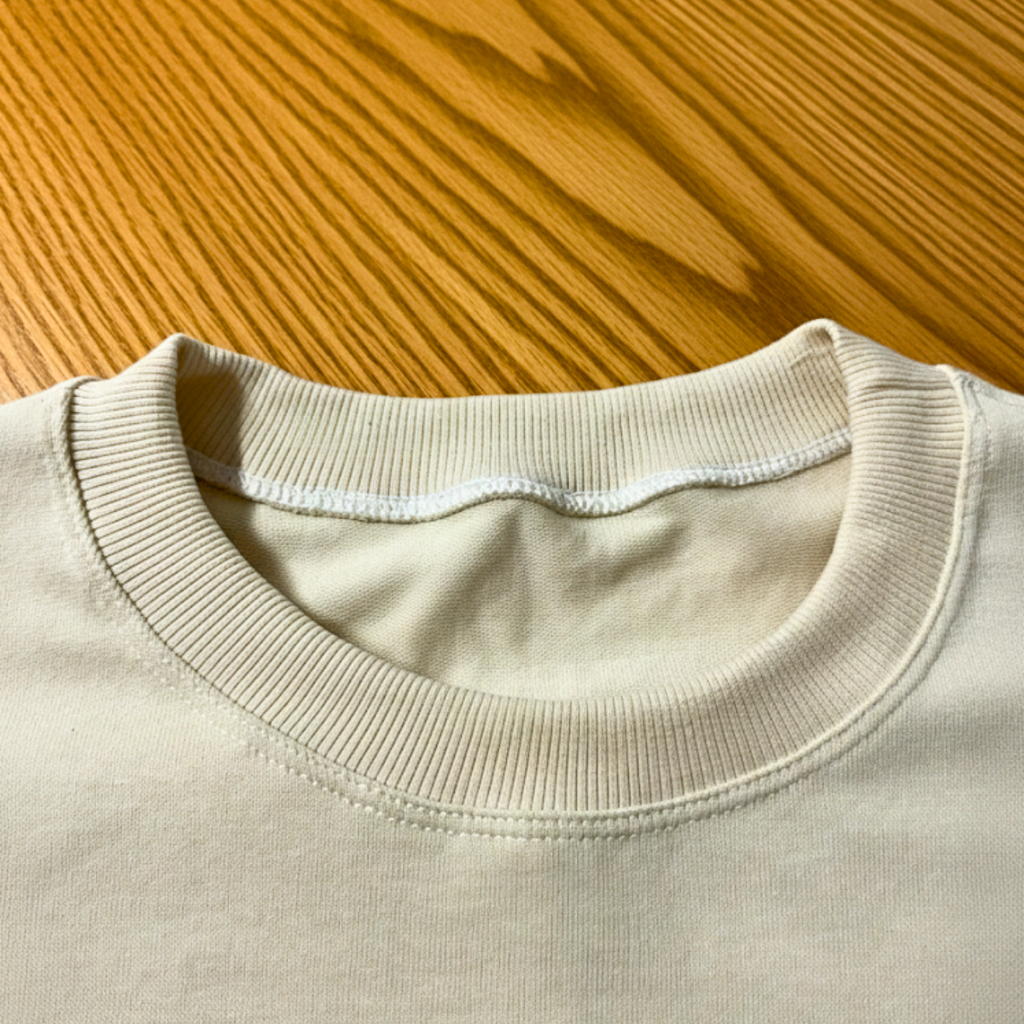 Close-up of a beige sweater collar on a wooden surface