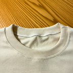 Close-up of a beige sweater collar on a wooden surface